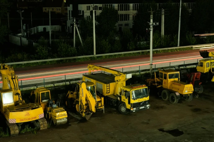 A group of construction trucks parked next to each other